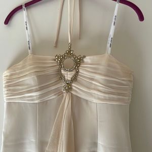 Cocktail designer dress, cream-colored with lots of details. Below the knee.